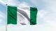 Nigerian flag flying against blue sky background