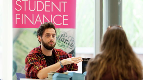 University of Westminster, Cavendish Campus Open Day 2014: a female student (back turned) talks to a male staff member at an information desk with a banner reading Student Finance