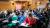 A seated audience, taking notes.