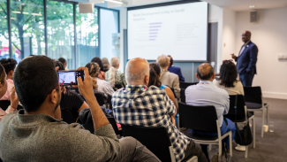 Group of people listening to a speaker present 