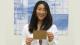 Girl with black hair holding a postcard at the University of Westminster