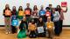 Group photo of Westminster attendees at the London Student Sustainability Conference holding colourful cards of the UN SDGs.