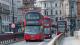 Three London buses driving on the road