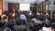 A photo from the back of the audience showing rows of people in front of a panel of alumni. 