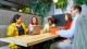 Group of students sitting around a table with laptops