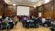 Panellists sit on a long table in front of the audience.