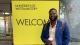 Student Lonceny Kourama stood in front of yellow University of Westminster WELCOME sign