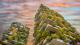 Looking up at two blocks of flats with balconies covered in plants.