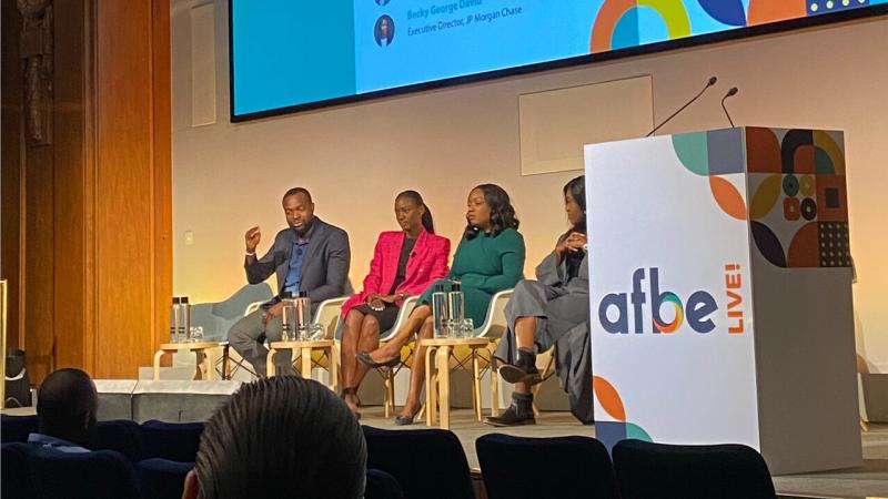 Four people sitting on a stage talking to an audience 