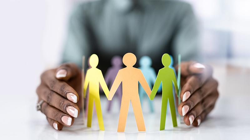 Equality Diversity Inclusion themed photo with a Black person holding colourful people silhouettes in between their hands