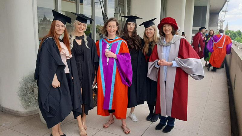 Dr Claire Robertson at graduation with students