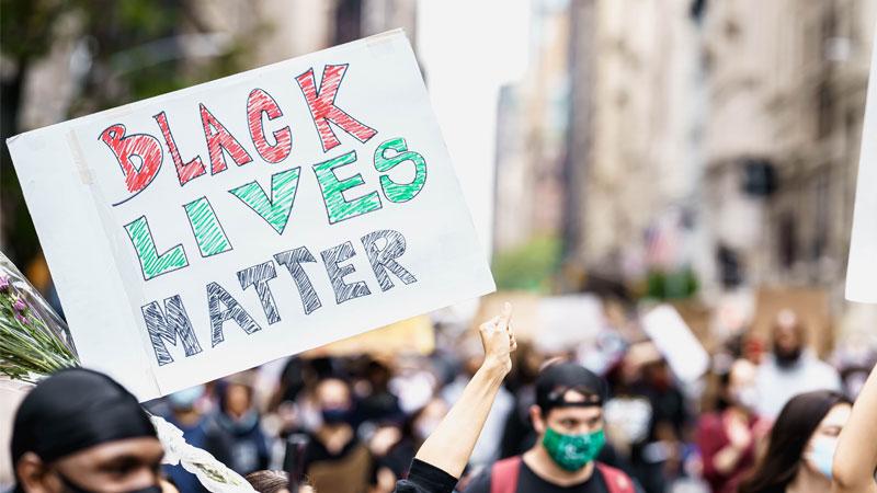 Someone holding up a poster in a BLM protest