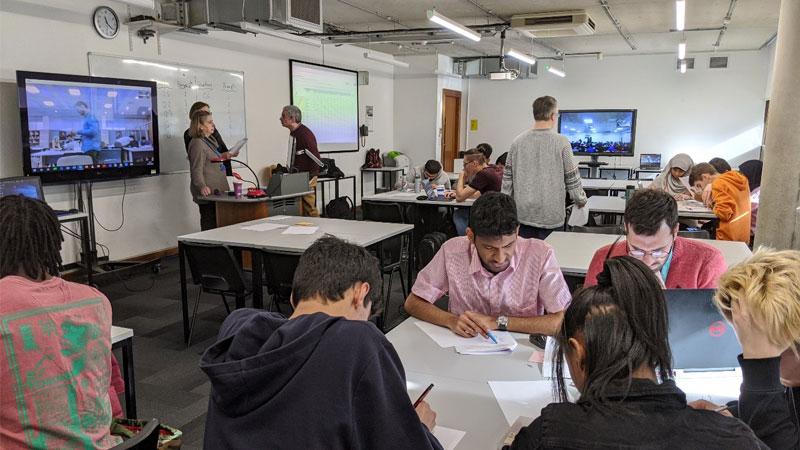 Teams working together around tables at last year's hackathon