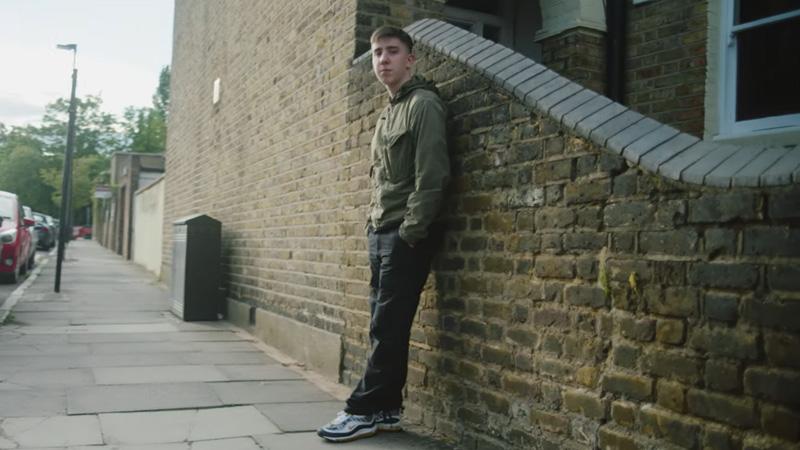 Westminster alumnus mustbejohn leaning against a brick wall posing to camera.