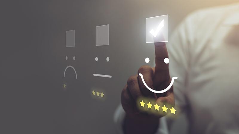 Businessman pressing smiley face emoticon on virtual touch screen.
